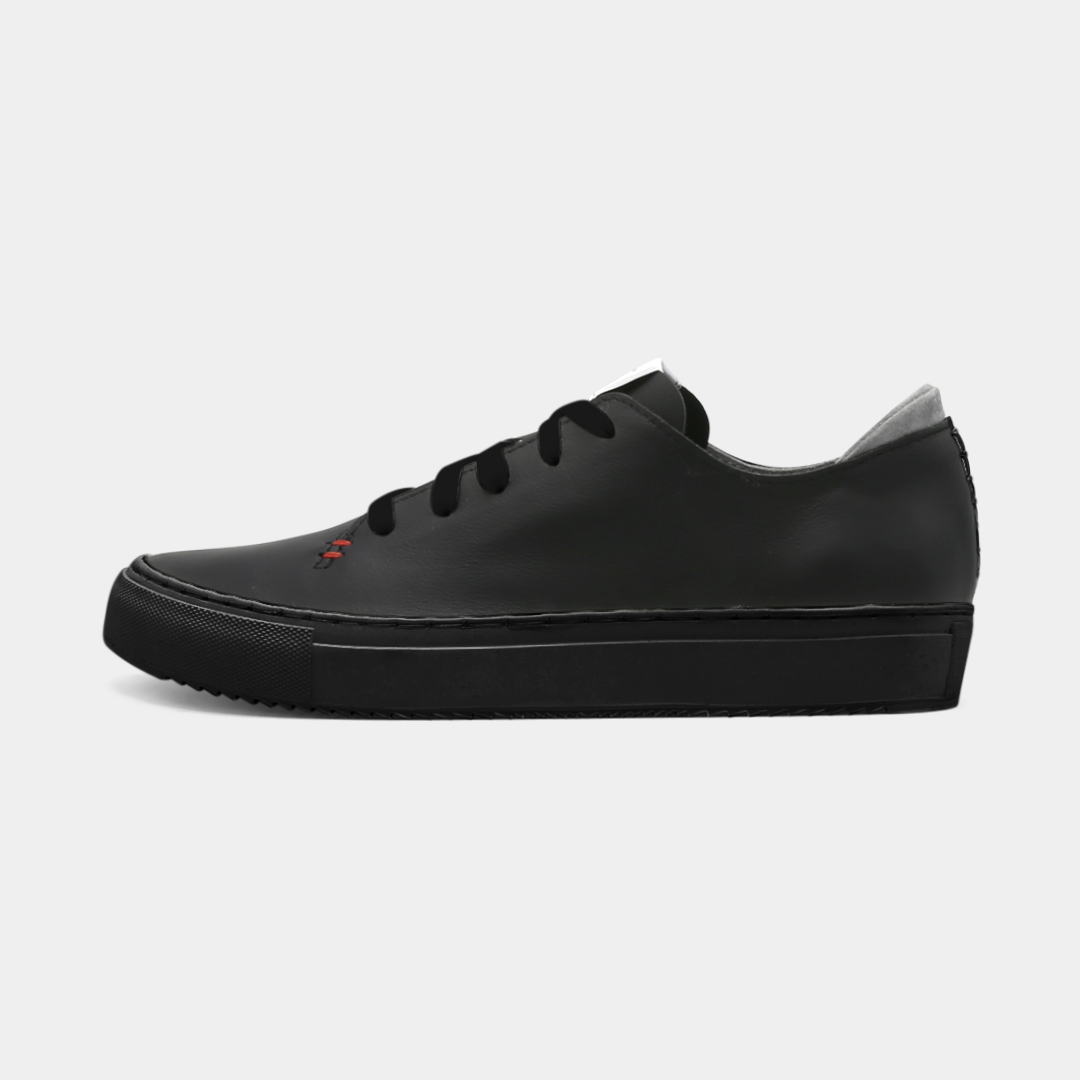 A black colored low-top sneaker with a black sole and laces, lateral view.