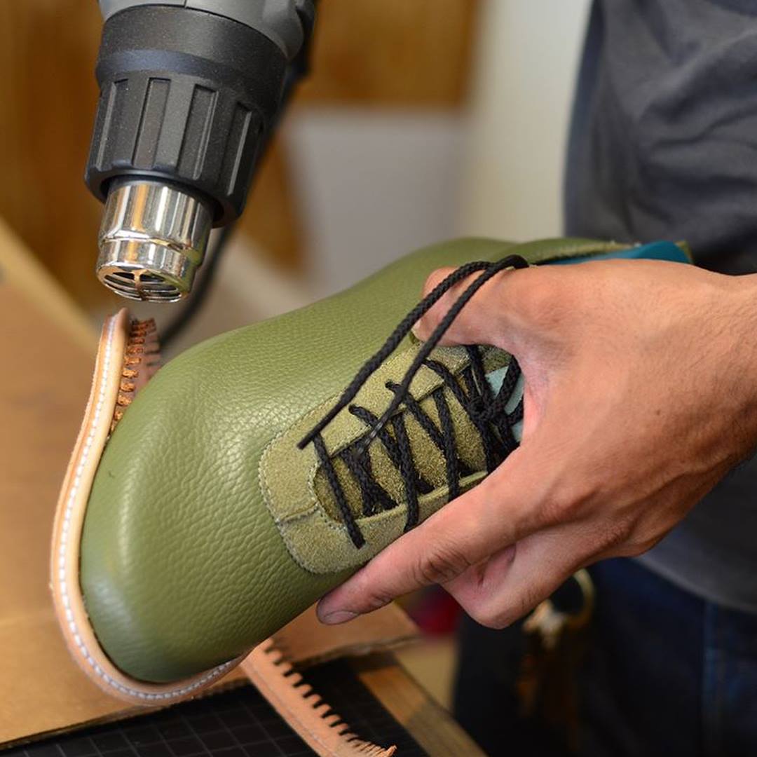 Photo of a green shoe that is having a welt applied to it