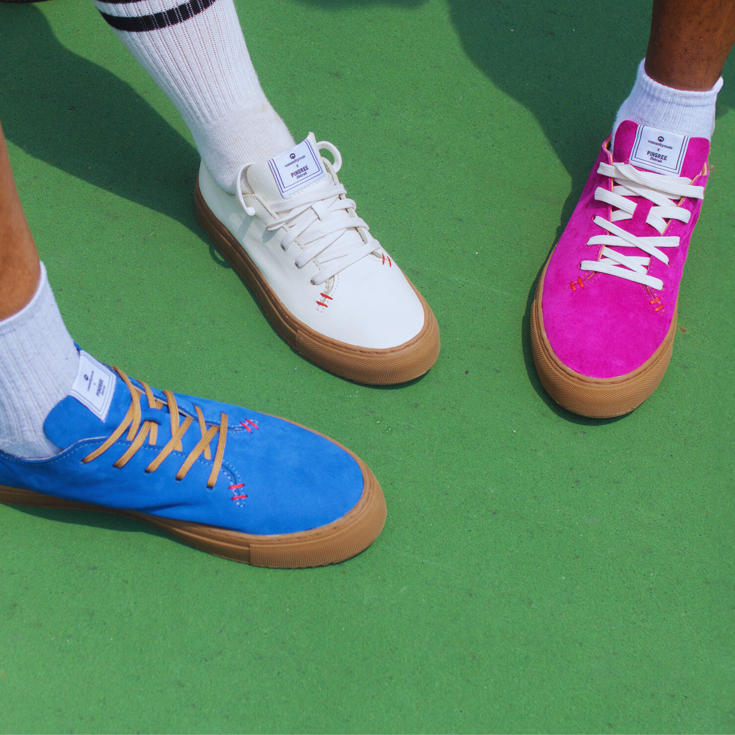 On foot picture of Blue, White and Pink sneakers on a green background