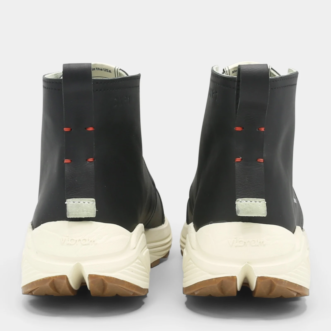 A black high-top urban utility chukka boot with white laces and a chunky white sole back view.