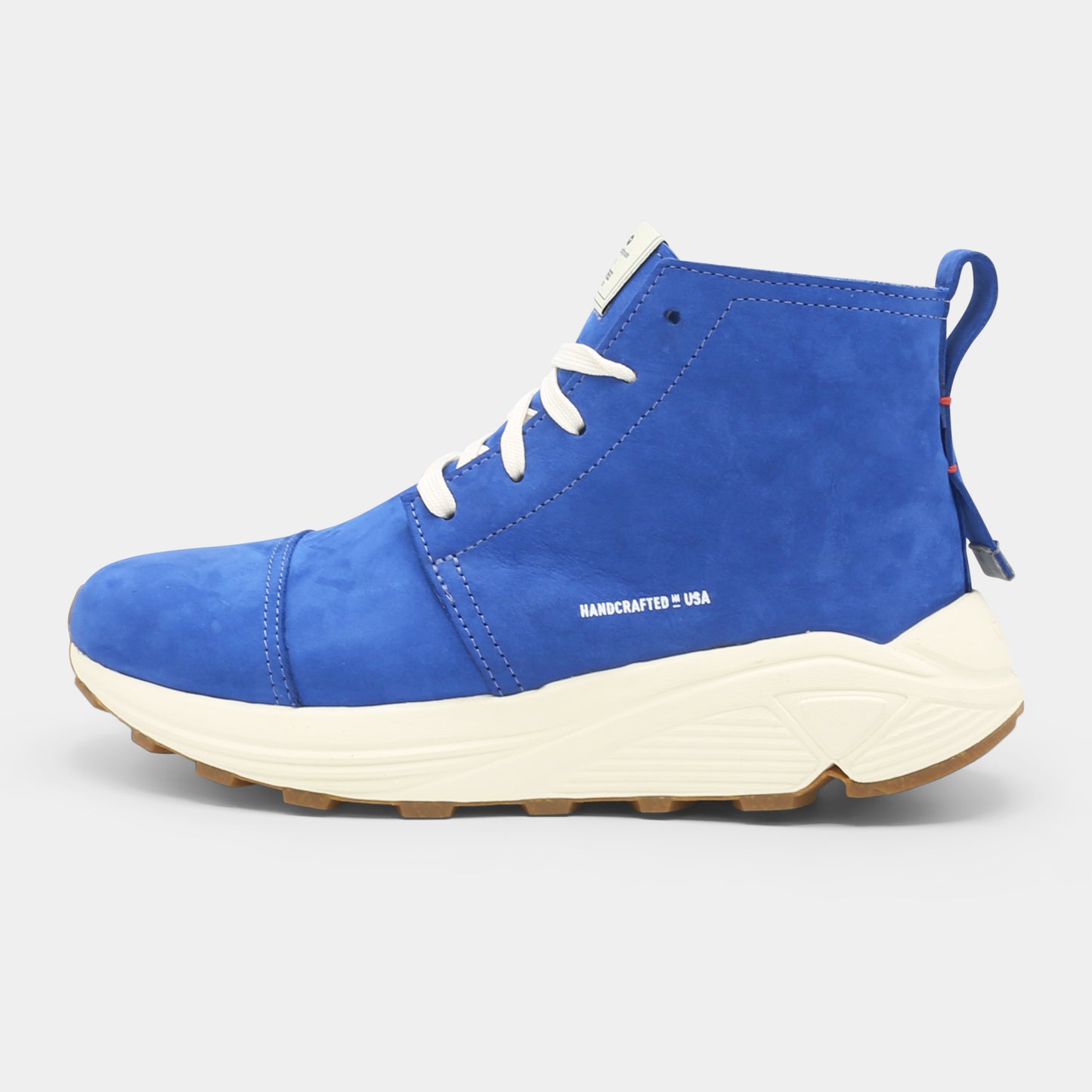 A blue high-top urban utility chukka boot with white laces and a chunky white sole lateral view.