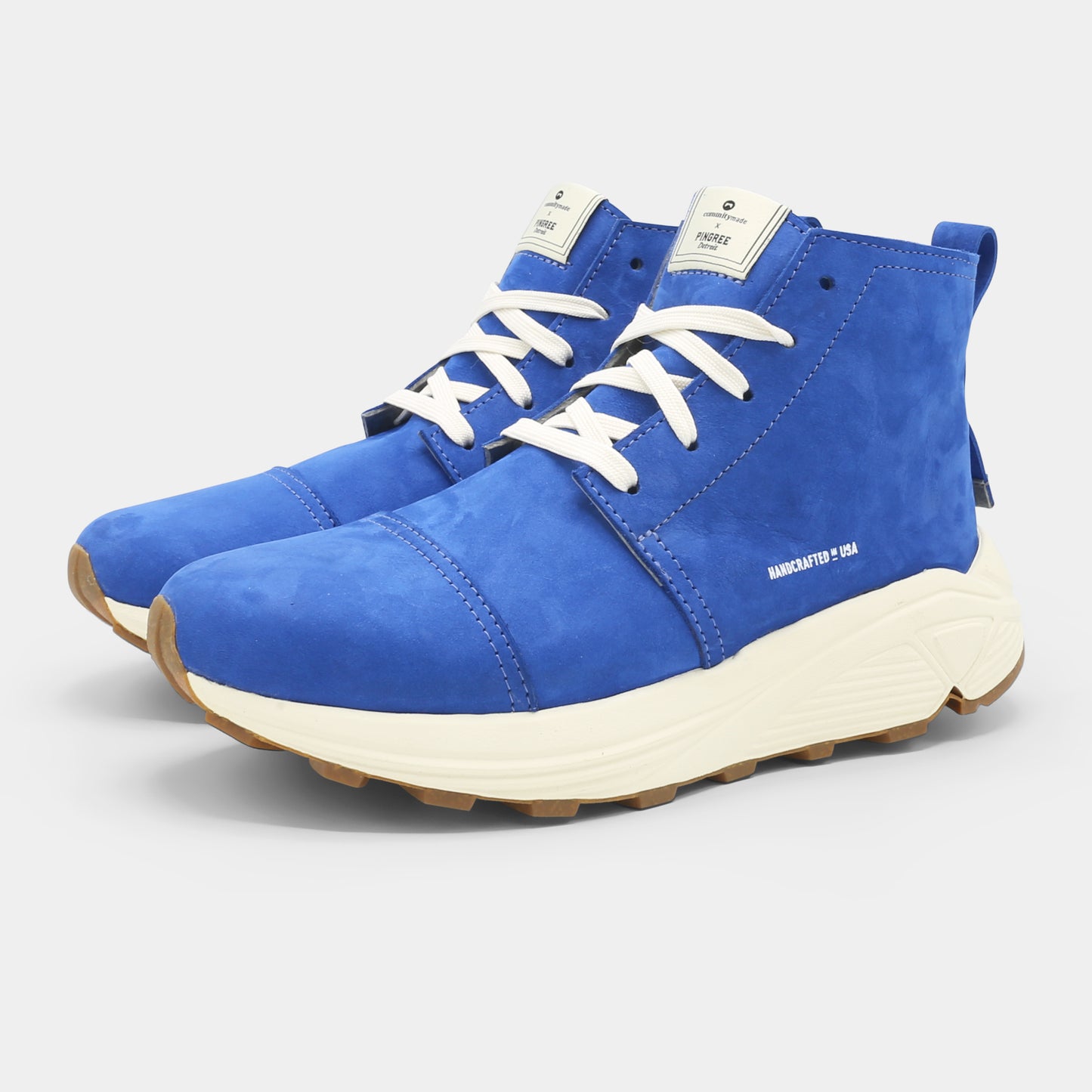 A blue high-top urban utility chukka boot with white laces and a chunky white sole quarter view.