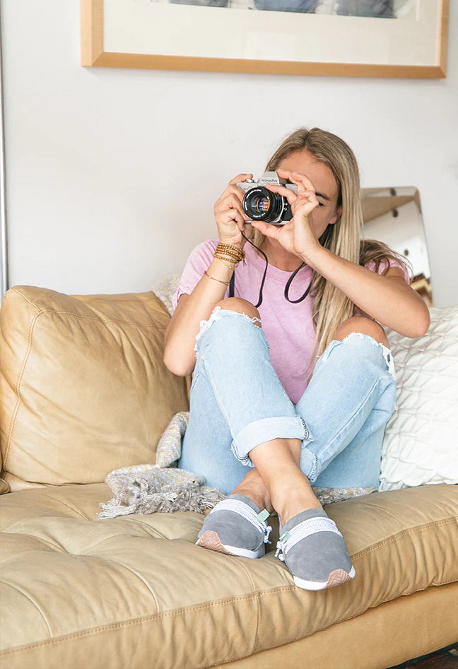 sage green mateos worn by a woman on the couch