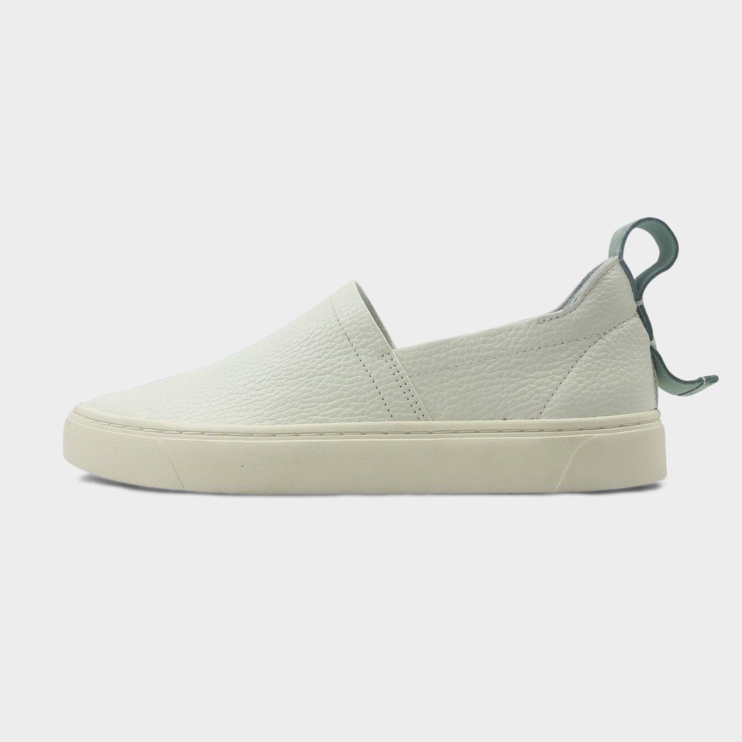 A white slip-on men's shoe with a suede and leather upper and a rubber sole lateral view