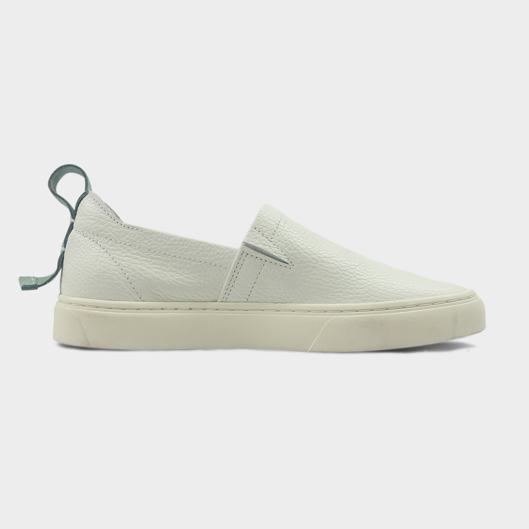A white slip-on men's shoe with a suede and leather upper and a rubber sole medial view