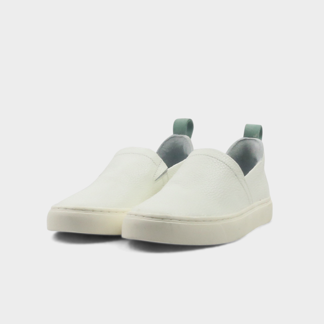 A white slip-on men's shoe with a suede and leather upper and a rubber sole quarter view