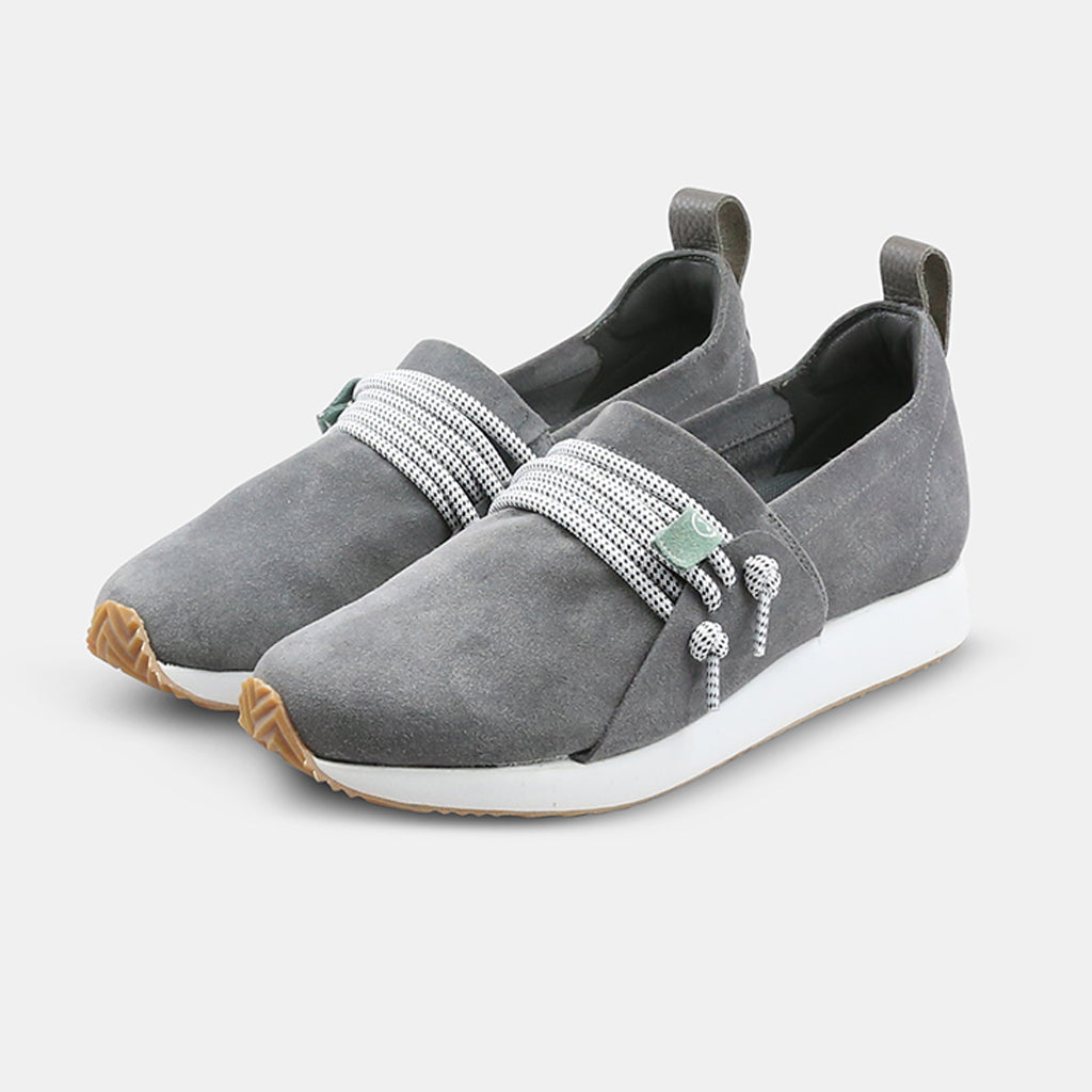 A quarter view profile picture of a grey suede COMUNITYmade Mateo sneaker with a white sole and lace-up closure, white midsole and gum rubber outsole and a leather heel loop pull tab