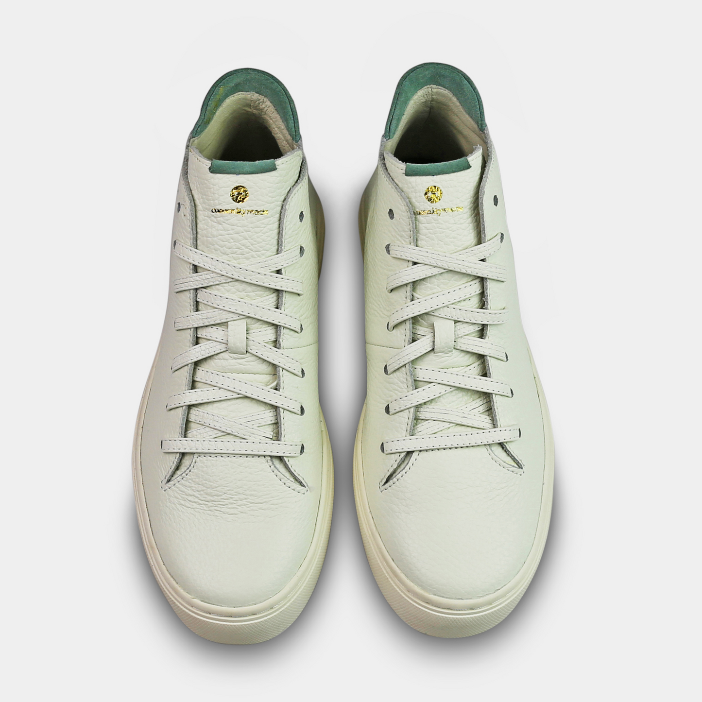 A white, mid-top sneaker with a leather upper, lace-up closure, and a white sole top view