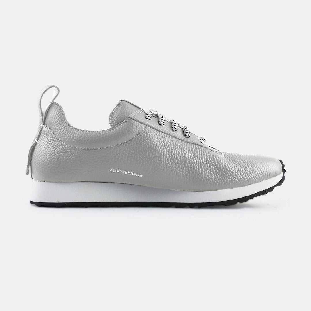 A pair of gray sneakers with a subtle grainy texture and white soles. A small mint green tag is at the base of the heel, just above the sole. A small white text logo is printed vertically on the back of each shoe.