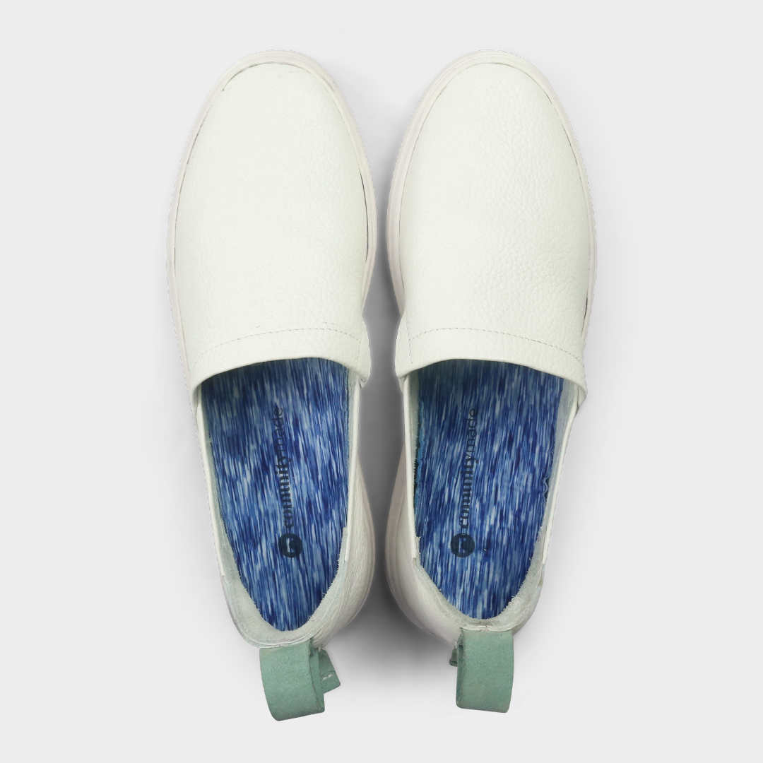 A white slip-on men's shoe with a suede and leather upper and a rubber sole top view